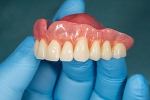 Dentist holding a denture