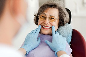 Dentist looking at patient's smile in treatment room