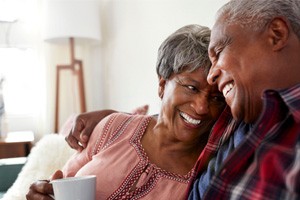 Senior couple smiling while drinking coffee at home