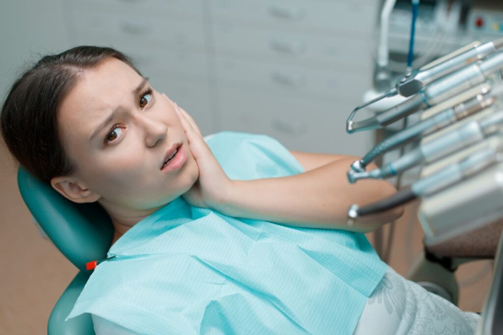 A woman holding her jaw in pain.